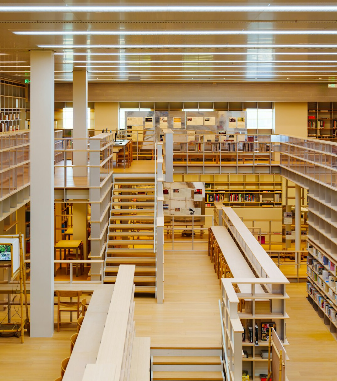 Quiet archive reading room with tall wooden shelves of books
